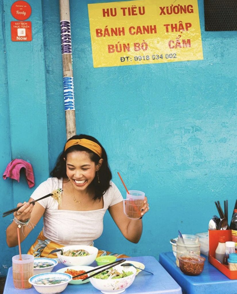 Filipina girl in headband eating Asian food.