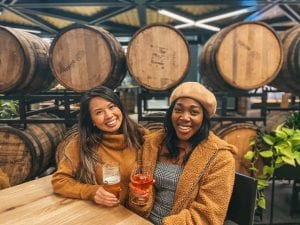 Two women enjoying beer inside a brewery