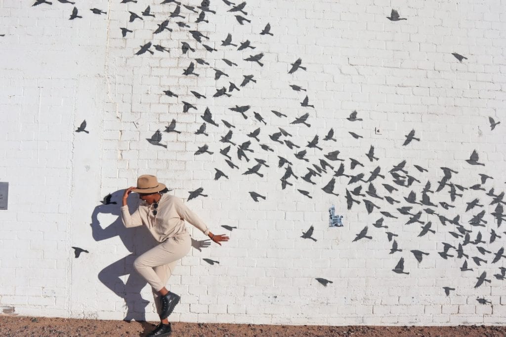 Girl posing in front of a bird mural wall in Arizona