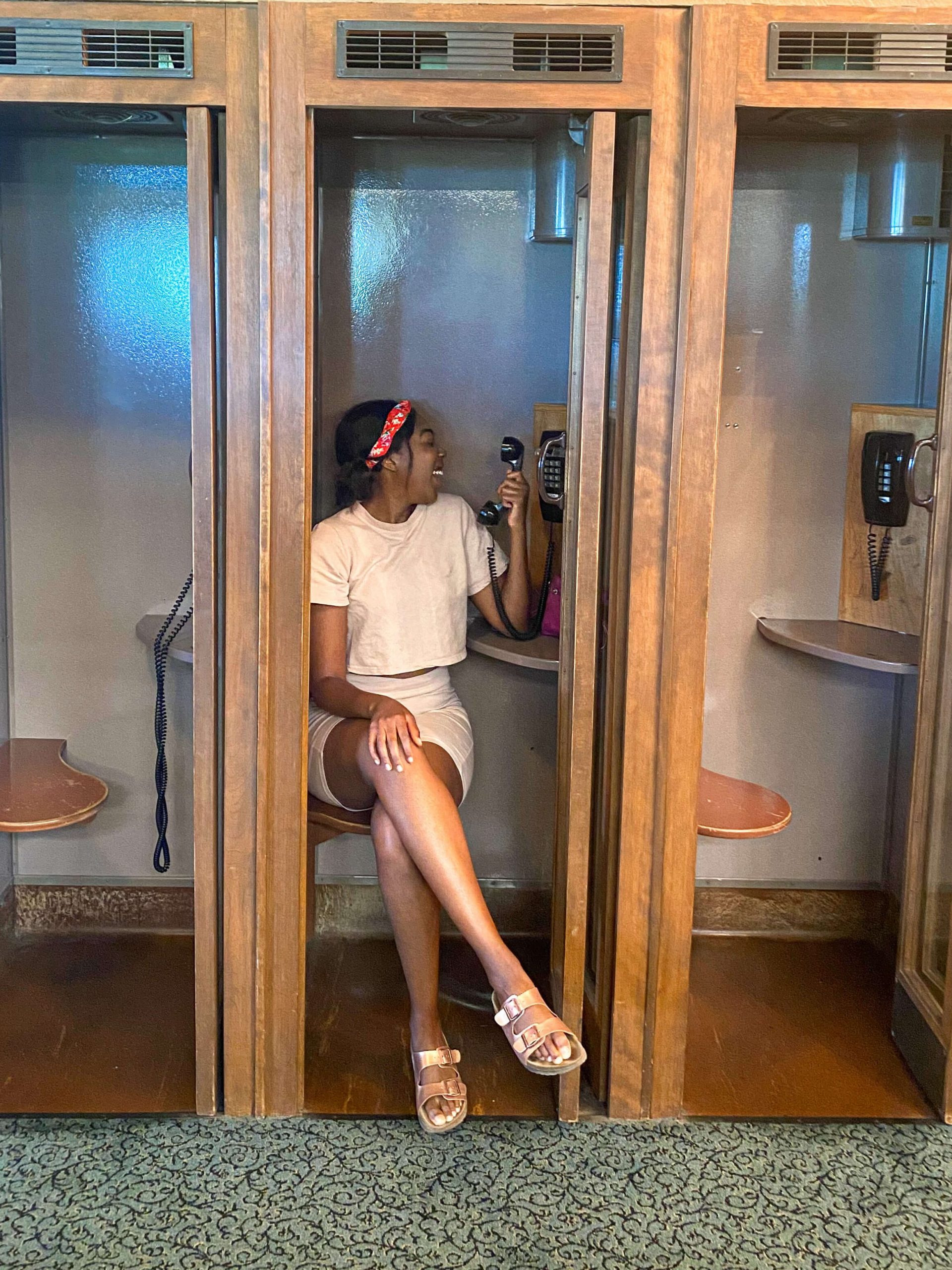 Girl sitting in phone booth in Brainerd, MN Madden's Resort 
