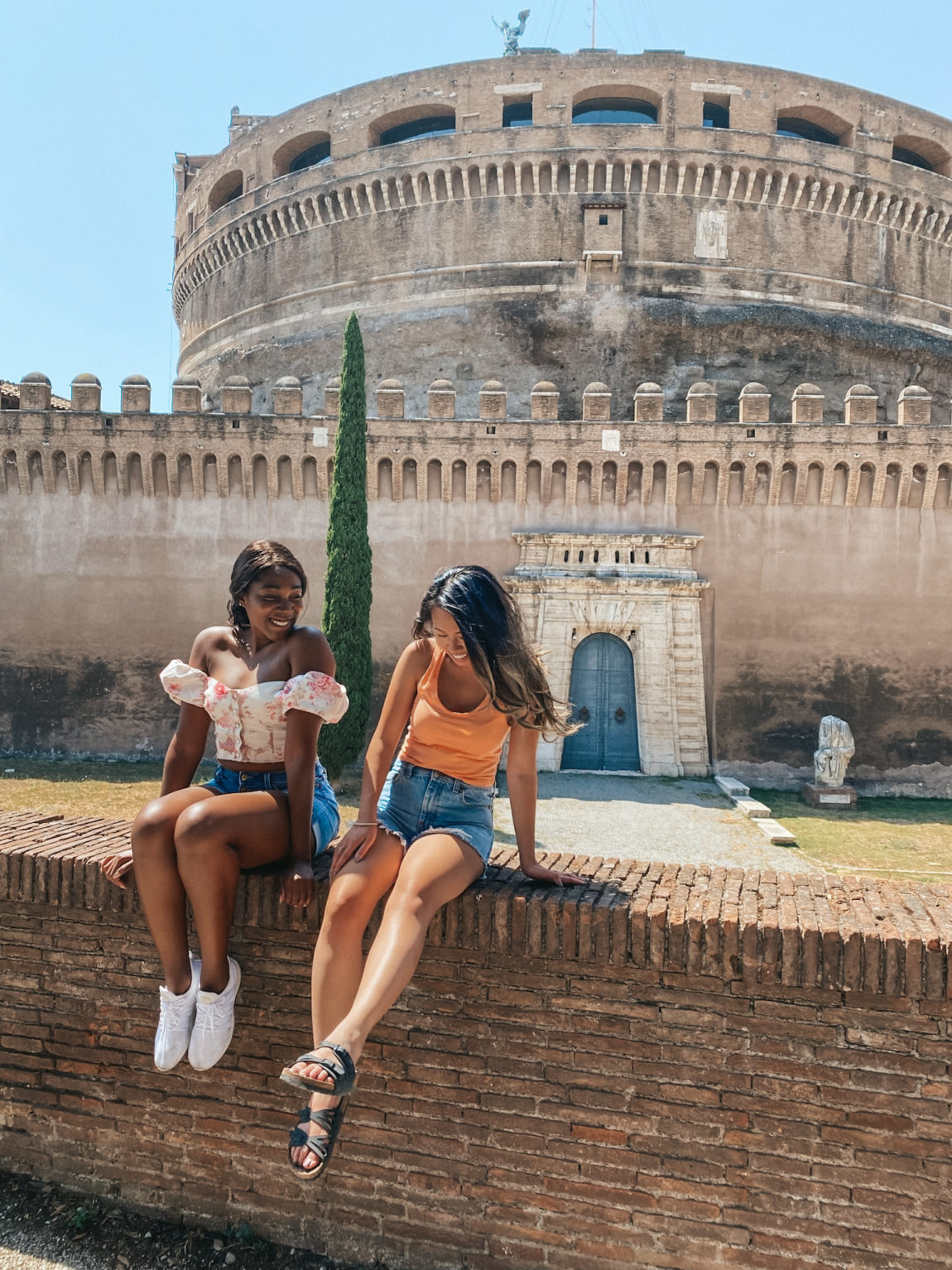 two girls sitting on a tower in Rome
