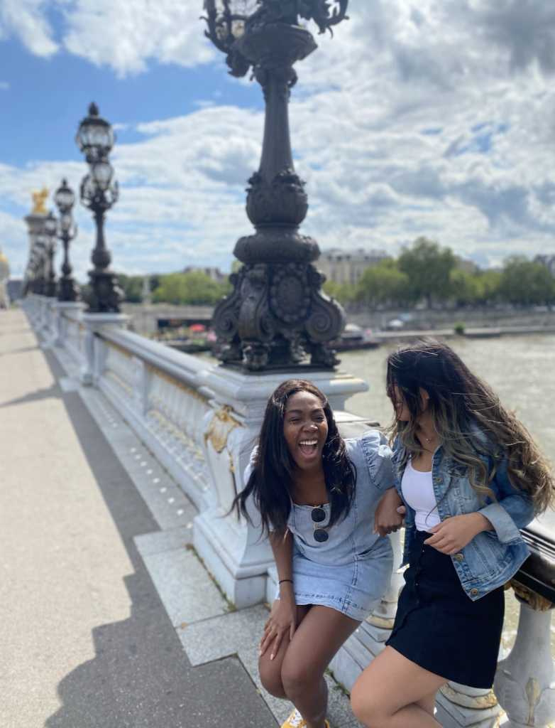 Two girls leaning against Ponte Alexandre III Bridge in Paris, France 