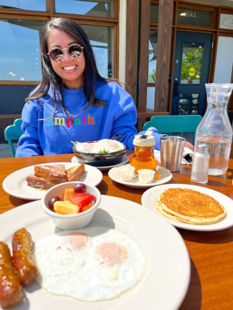 woman in blue sweatshirt with breakfast food