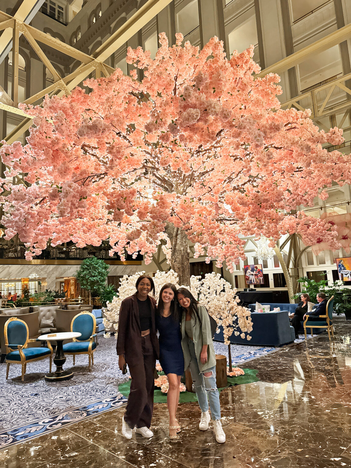 three girls in front of cherry blossoms inside a hotel in Washington DC